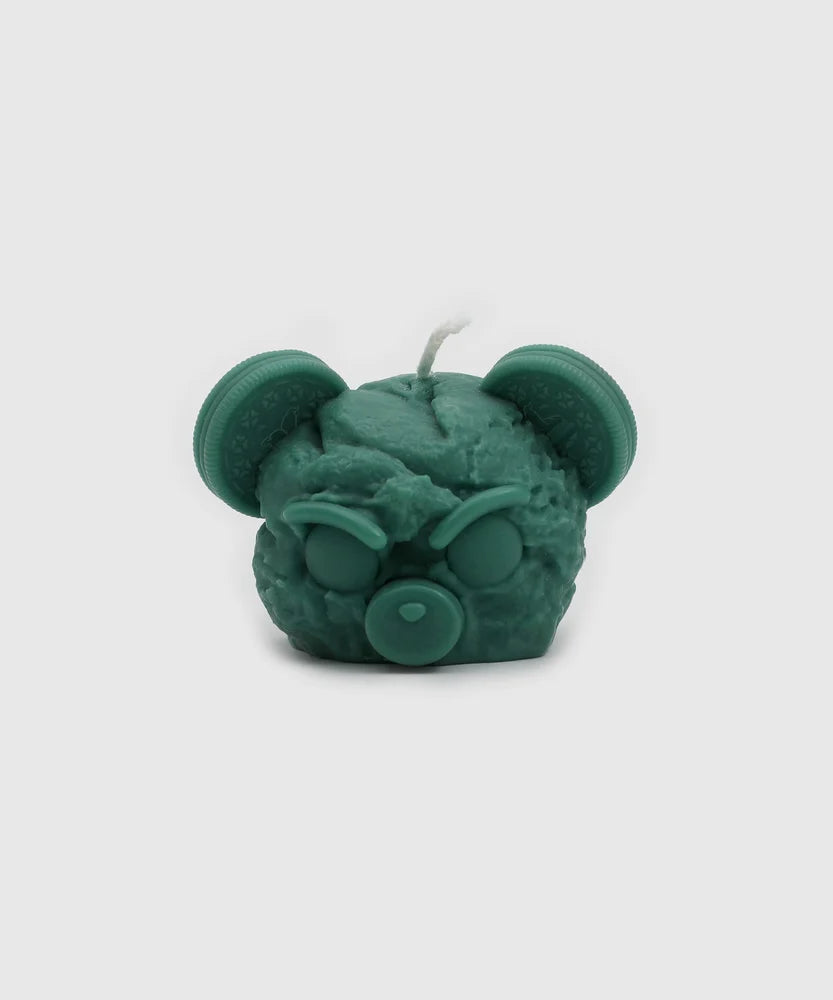 Front-facing green candle shaped like an angry bear head, featuring cookie ears, closed eyes, a pacifier nose, and a sculpted texture – part of the Sucux Cool Collection.