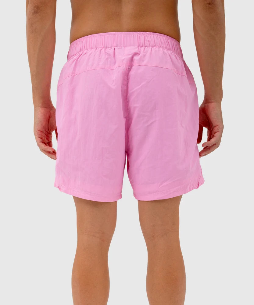 Back view of a person wearing light pink swim shorts with an elastic waistband and clean seam detailing – part of the Sucux Cool Collection.