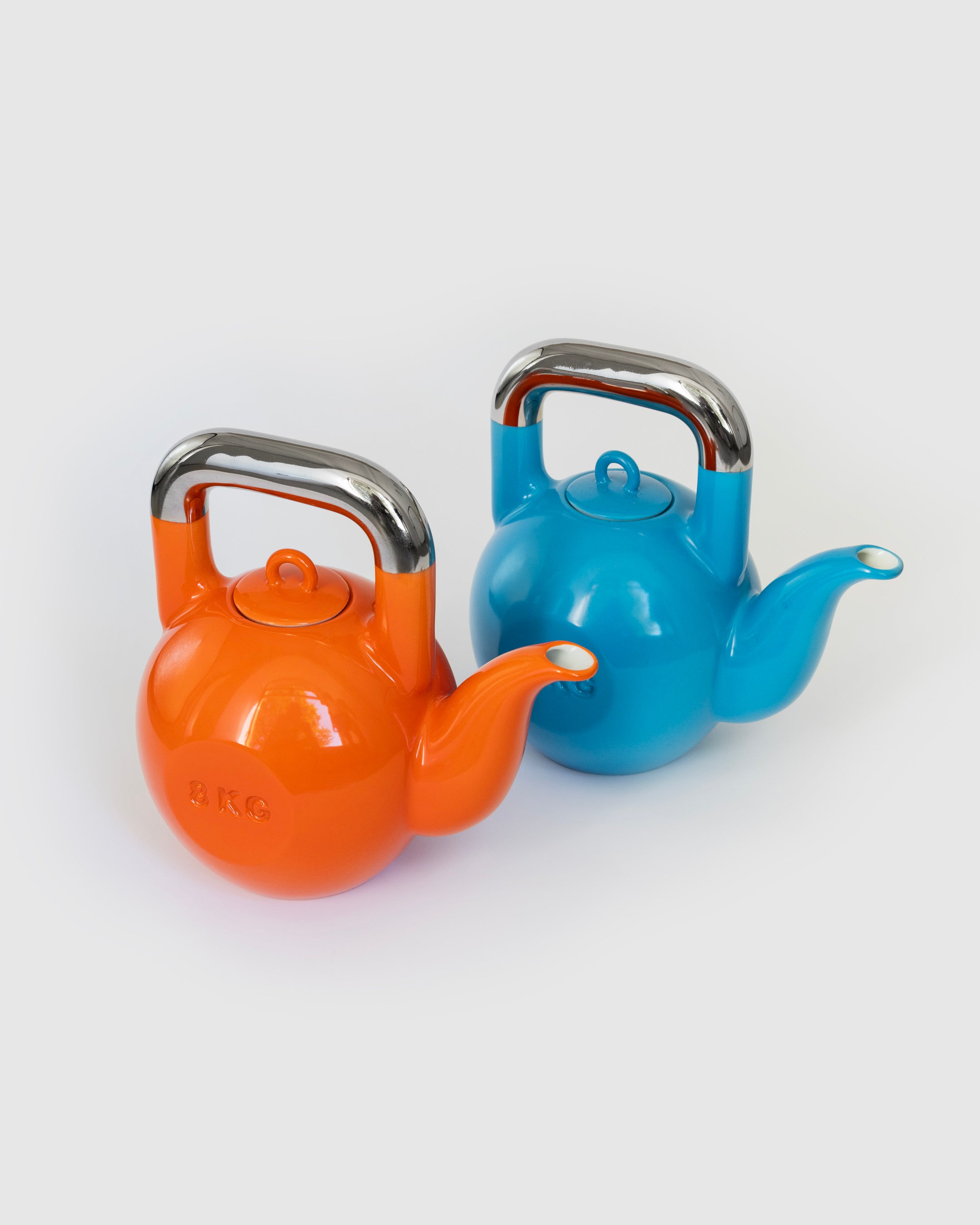 Blue and orange Kettlebell Teapots displayed together