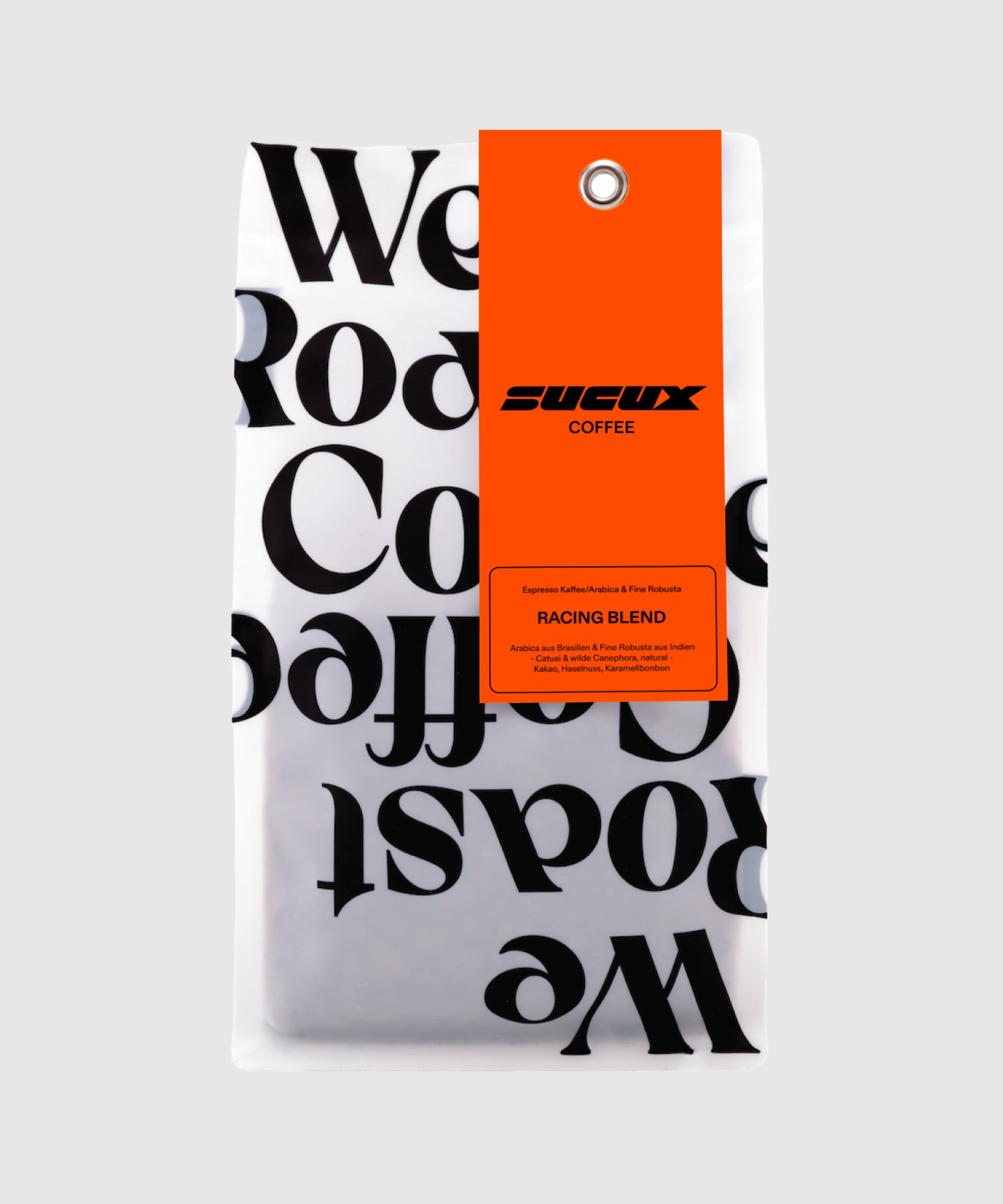 A white coffee bag with bold black typography and an orange label featuring the “SUCUX COFFEE” logo and “Racing Blend” product details.